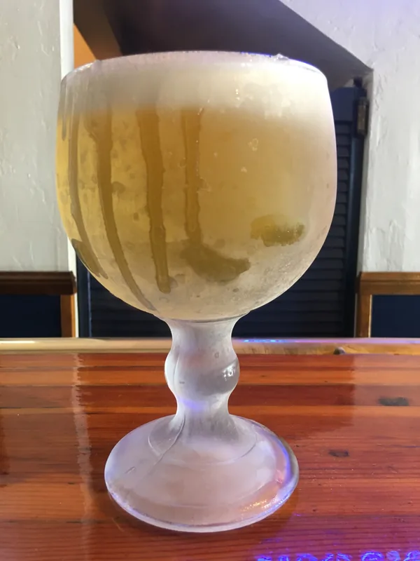 An ice-cold schooner of draft beer on the bar